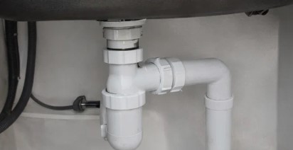 The now-empty trap and pipework underneath